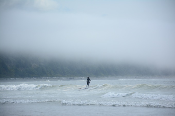 Weather can change quickly. 5 minutes prior to this photo, there was nothing but blue skies and sunshine. Here, a surfer enjoys the waves at a beach not far from Black Rock.